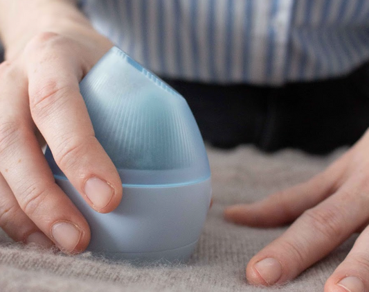 person debobbling cashmere with fabric shaver