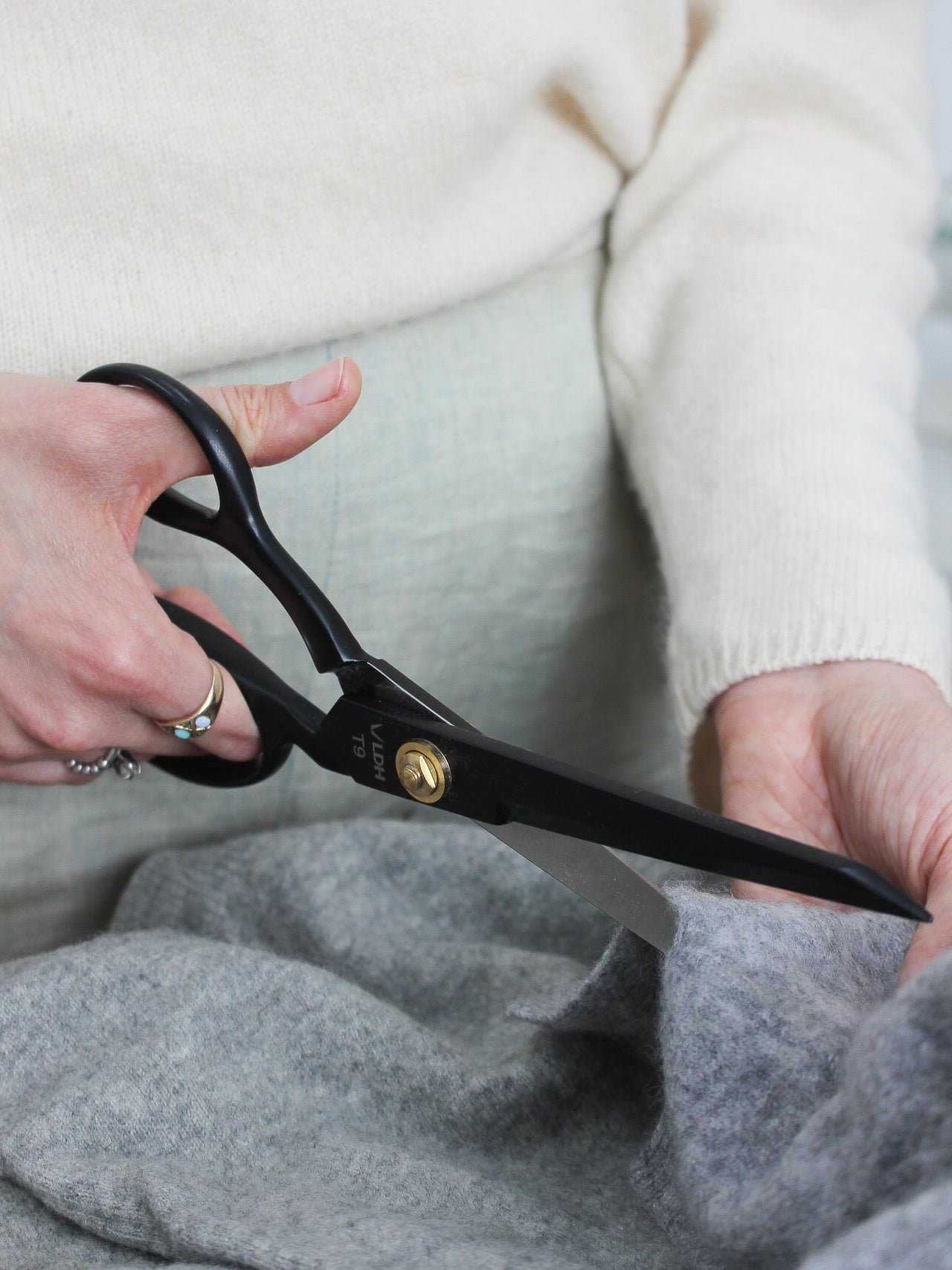 Person holding black scissors with a blurred background