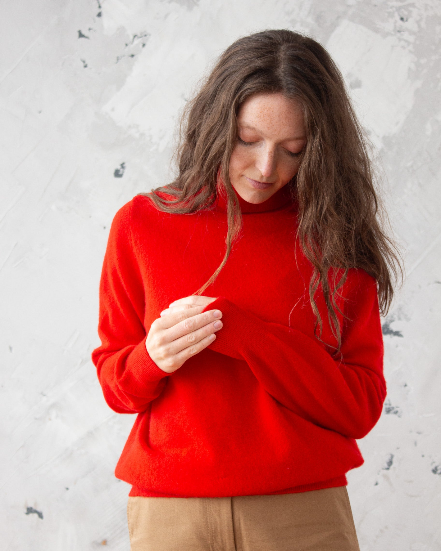 Woman wearing red cashmere roll neck jumper