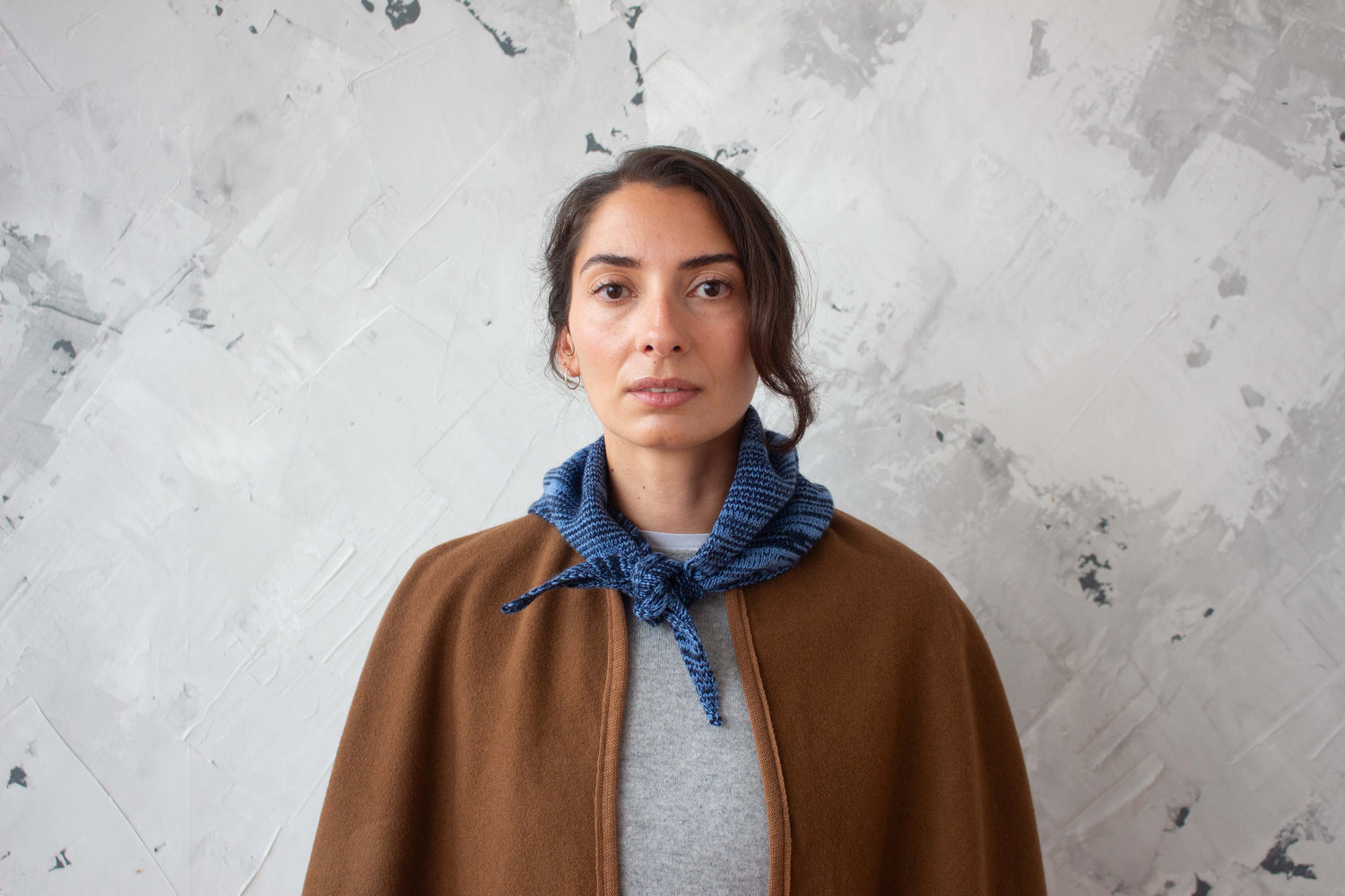 Woman wearing secondhand cashmere cape and knitted scarf